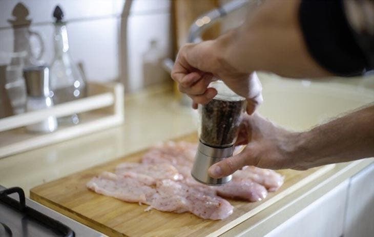 Ajouter des épices sur la poitrine de poulet