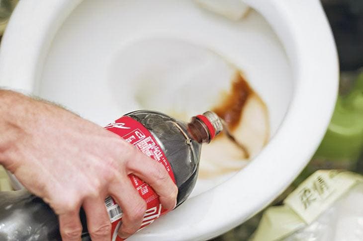 Bouteille de Coca versée dans les toilettes