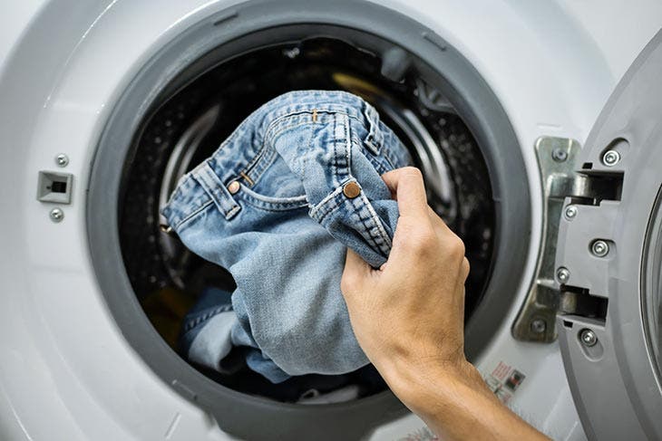 Introduction d’un jean dans la machine à laver 