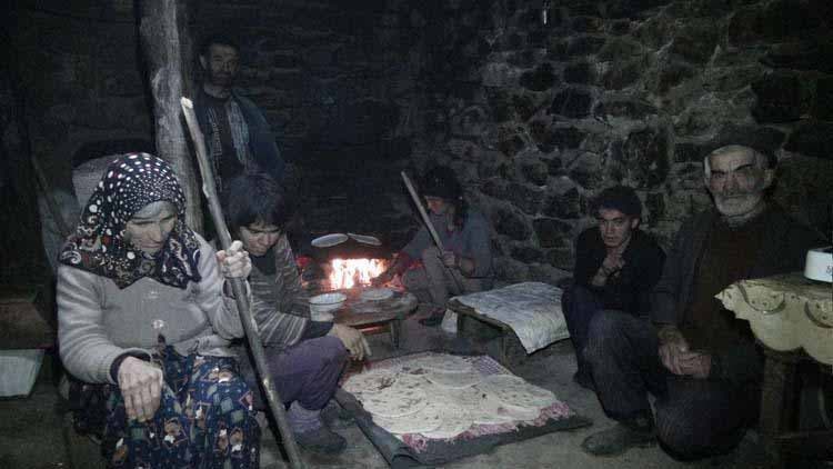 La famille assise dans le noir avec comme seule lumière, du feu de bois