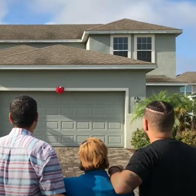 LeJuan avec ses parents devant leur nouvelle maison