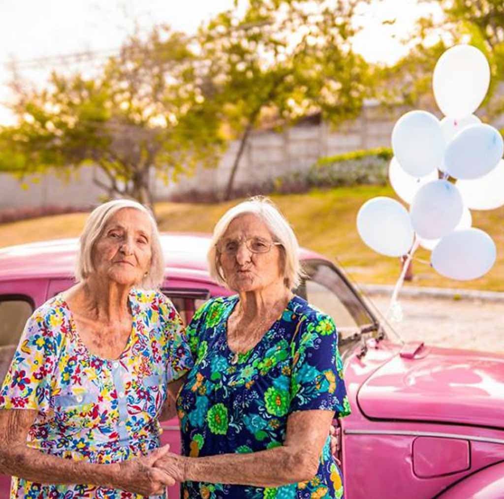 Les sœurs jumelles prennent une photo avec une voiture en rose