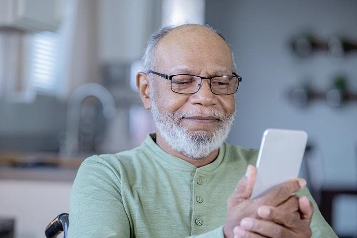 Personne âgée tenant un smartphone. source : spm