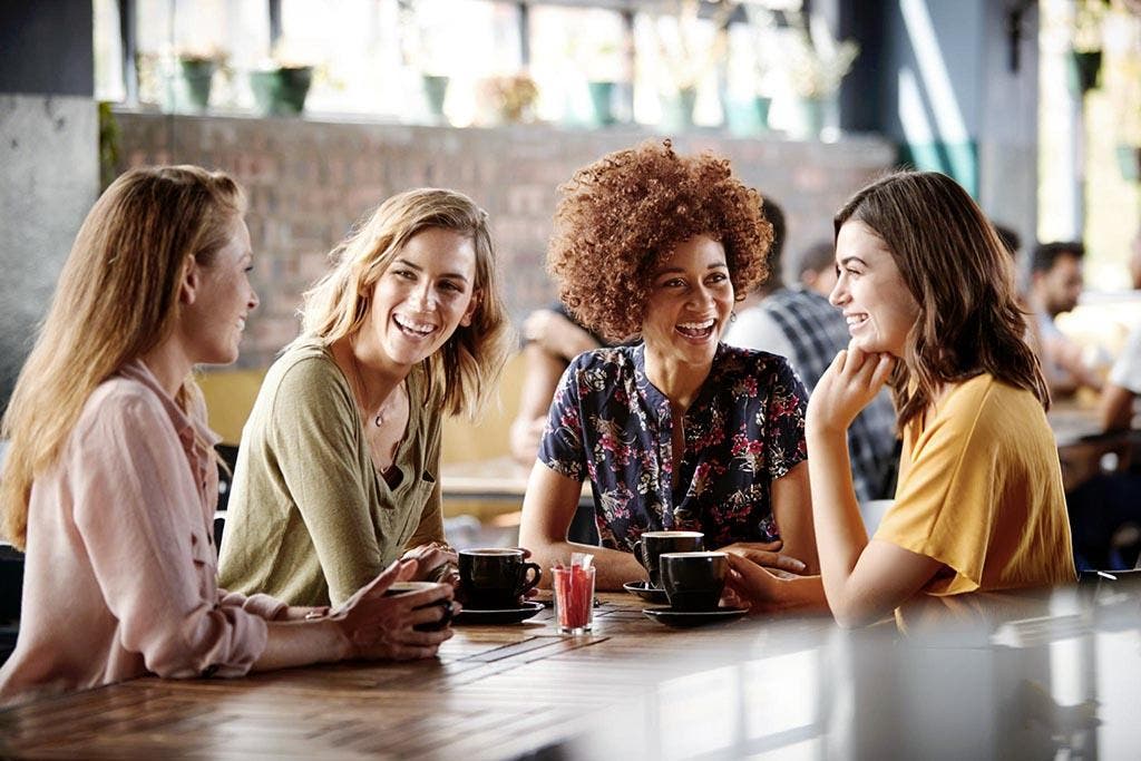 Quatre femmes en train de rire et parler