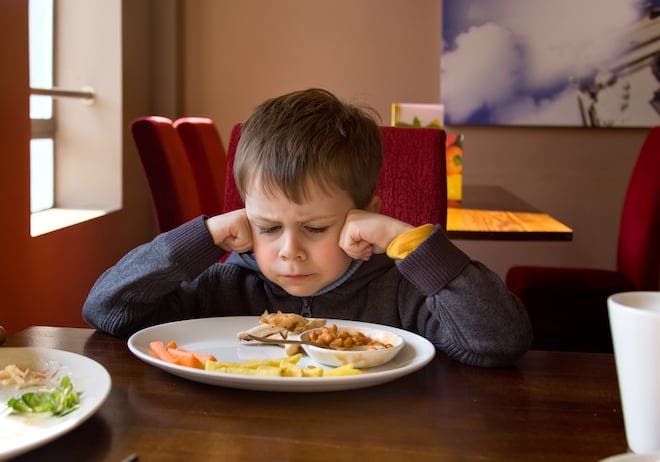 Un enfant énervé sur la table du restaurant