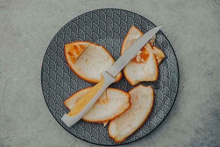 Des écorces d’oranges sur une assiette 