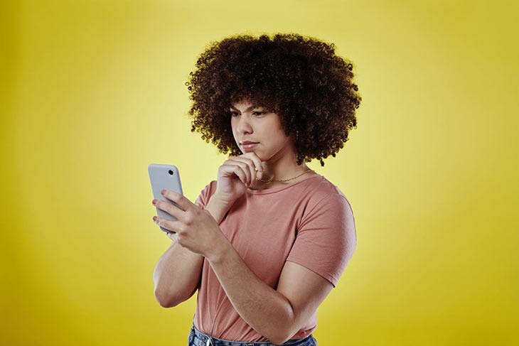 Femme perplexe devant l’écran de son smartphone. source : spm